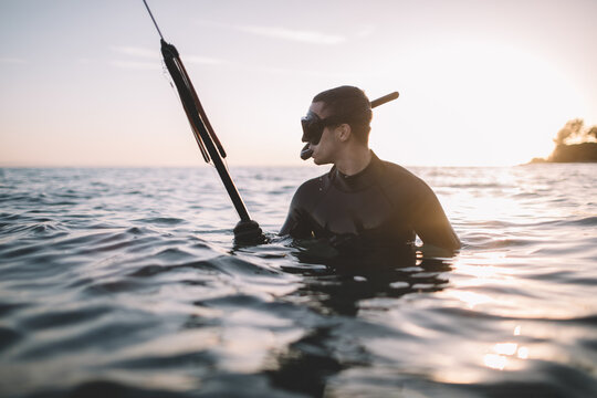 Young active man in water holds a speargun and ready for spearfishing