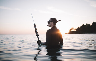 Spearfisherman in the water holds spear gun