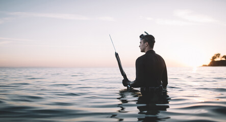 Side view of man in water ready for spearfishing, copy space