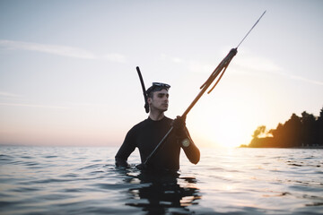 Young active man in water ready for spearfishing