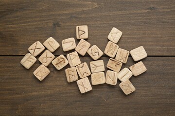 Runes with different symbols on wooden table, flat lay