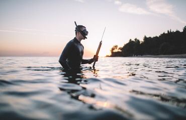 Spearfisherman in the water holds spear gun