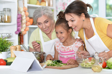 Portrait of a cute happy family coocking salad at kitchen