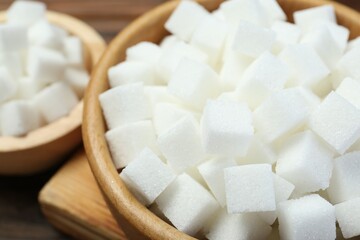 White sugar cubes on wooden table, closeup
