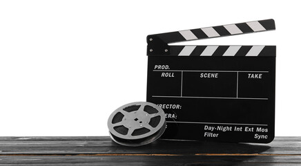 Movie clapper and film reel on wooden table against white background, space for text