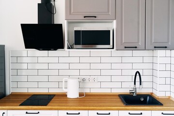 White cabinets with wooden counter of modern kitchen. High quality photo