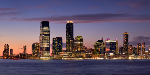 Panoramic view of Downtown Jersey City at twilight. Waterfront view of the Hudon River and Exchange Place skyscrapers, New Jersey
