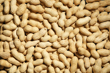 Many fresh unpeeled peanuts as background, top view