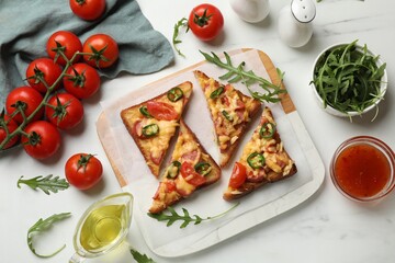 Tasty pizza toasts and ingredients on white marble table, flat lay