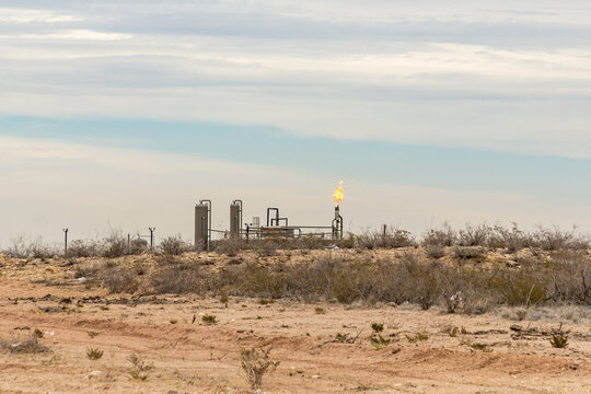 Midland, TX, US-March 31, 2024: Burning excess natural gas at a fracking pad on the Permian Basin.