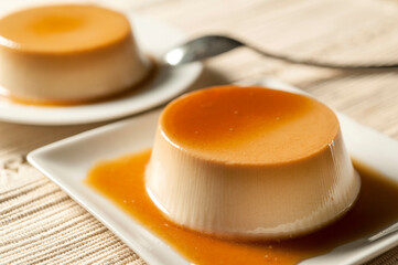Two egg and milk flats with liquid candy on white dishes