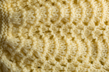 Fragment of hand knitted fabric yellow. beautiful pattern. full frame.