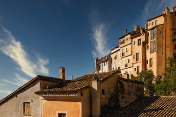 The architecture of the historic old town of Cuenca, Spain, with a blue sky in the background