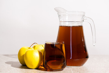 Apple juice in a glass and jug on a white background
