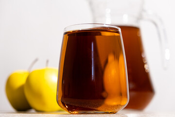 Apple juice in a glass and jug on a white background