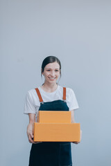 Smiling Asian woman in casual clothes holding a cardboard box mockup while standing against an isolated white background. shipping business concept