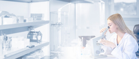 Woman scientist with microscope. Laboratory assistant works sitting at table. Girl researcher. Scientist conducts chemical research. Woman employee of industrial laboratory. Chemist, biologist