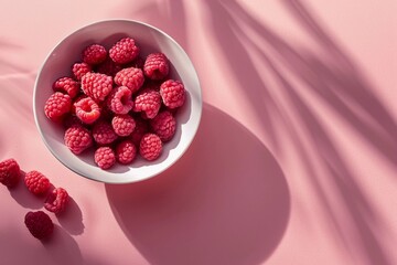 Raspberries in plate on pink background. Summer tasty berries.