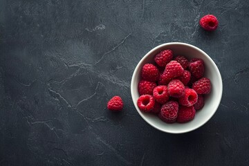 Raspberries in plate on dark background. Summer tasty berries.