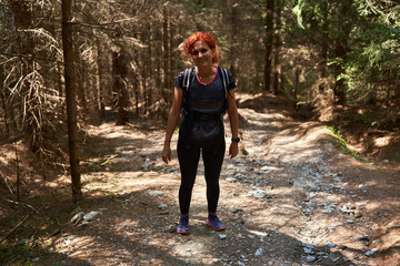 Woman hiker with backpack in a pine forest