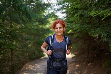 Woman hiker with backpack in a pine forest