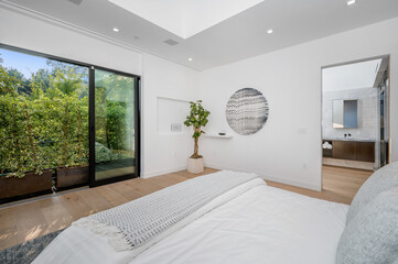 a bedroom with white walls and wooden flooring on the other side