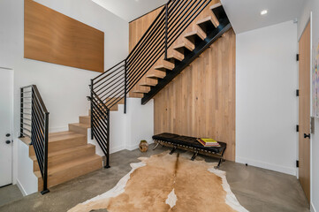 a white stair case with wooden floors and a wooden handrail