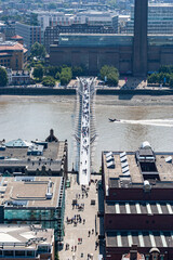 Looking down on the London Millennium pedestrian bridge over the Thames River from the City of London borough towards the Tate Modern art museum.