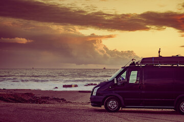 Camper van on beach at sunrise