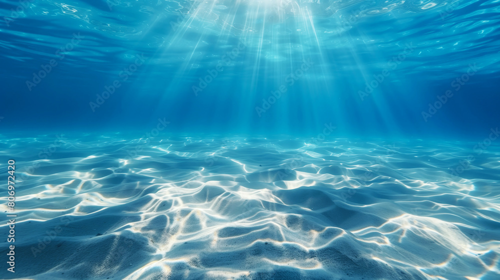 Sticker underwater view with bright sunlight streaming through blue water onto a sandy bottom.