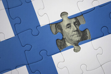 puzzle with the national flag of finland and usa dollar banknote. finance concept