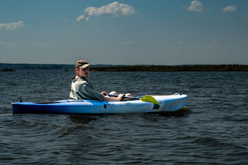 Broomes Island, Maryland USA A young man kayaks on the Patuxent River on a sunny day.