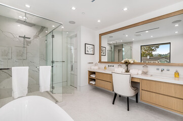 a large, modern bathroom features glass partitions to create an open feel