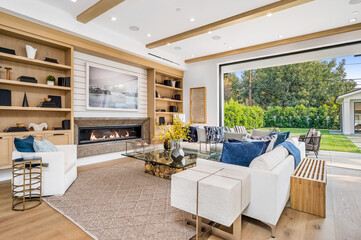modern living room with fireplace, furniture and large windows at the end of the room