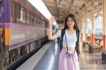 Asia woman traveler using a vintage film camera while waiting for the train, Travel and lifestyle...