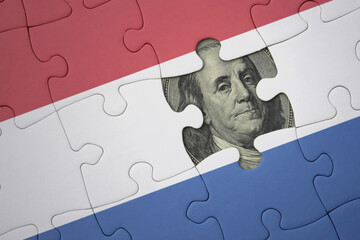 puzzle with the national flag of netherlands and usa dollar banknote. finance concept