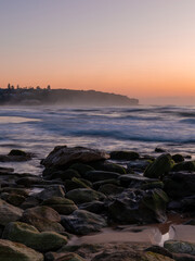 Rocky coastline of Curl Curl Beach at dawn.