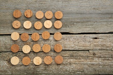 Runes with different symbols on wooden table, flat lay. Space for text