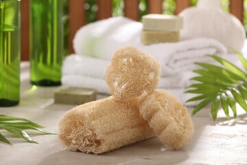 Natural loofah sponges on grey textured table