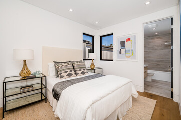 a clean bedroom with white walls and hardwood floors is shown