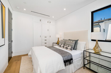 a bedroom with white walls and hardwood floors is featured in this photo