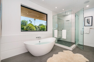 a bathroom with a glass shower and big tub in it