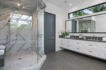 a bathroom with marble tile and double vanity tops and sinks