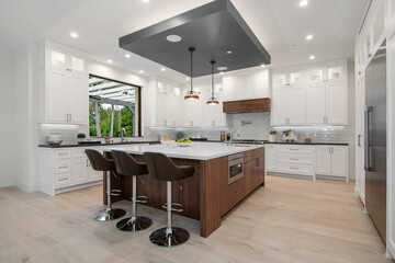 a kitchen with two bar stools next to a marble countertop