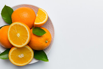Flat lay of Fresh orange fruit with sliced in plate on Colored background. Top view with copy space