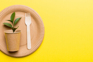 set of empty reusable disposable eco-friendly plates, cups, utensils on light white colored table background. top view. Biodegradable craft dishes. Recycling concept. Close-up