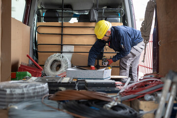 Man looking for tools in work truck trunk.