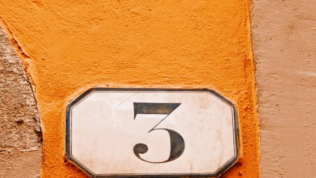 Number 3 (three) affixed to the exterior of a building, with an elegant, vintage and traditional appearance