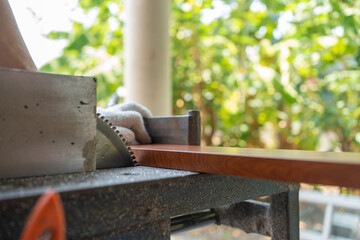 Close up Hand of man use an electric saw to cut aluminum with a wood pattern. Selective focus at saw.
