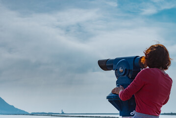 Woman using tourist binoculars, Cabo de Gata, Spain